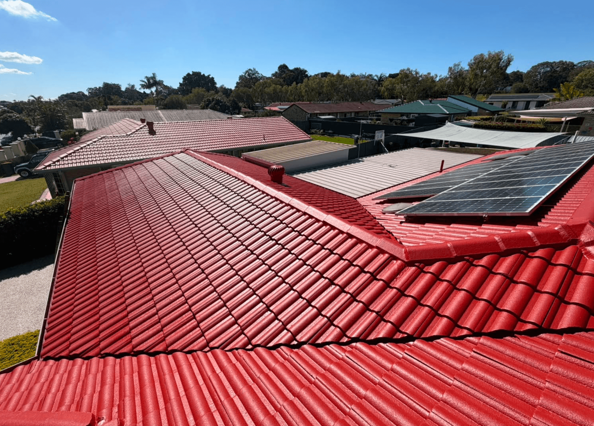 Freshly coated red concrete tile roof with solar panels in Narre Warren, painted by Northern Star Painting