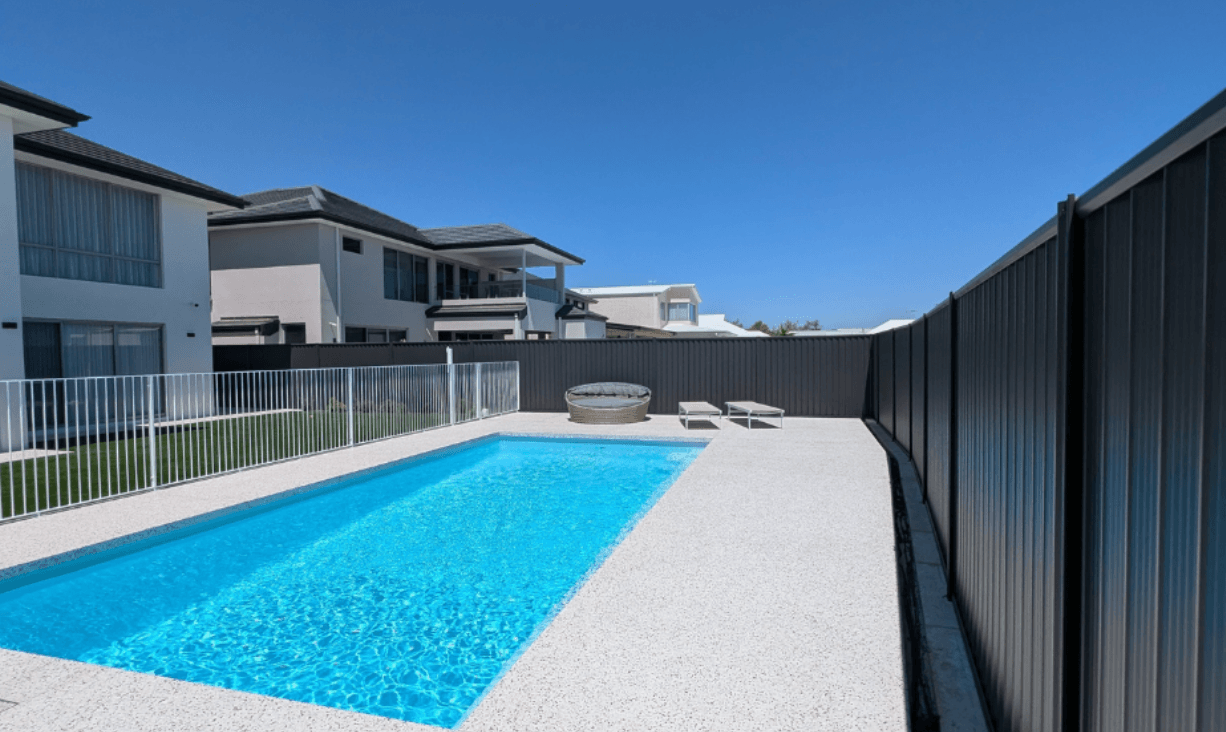 Charcoal Colorbond boundary fence and pool area at a modern two-storey home in Berwick, painted by Northern Star Painting