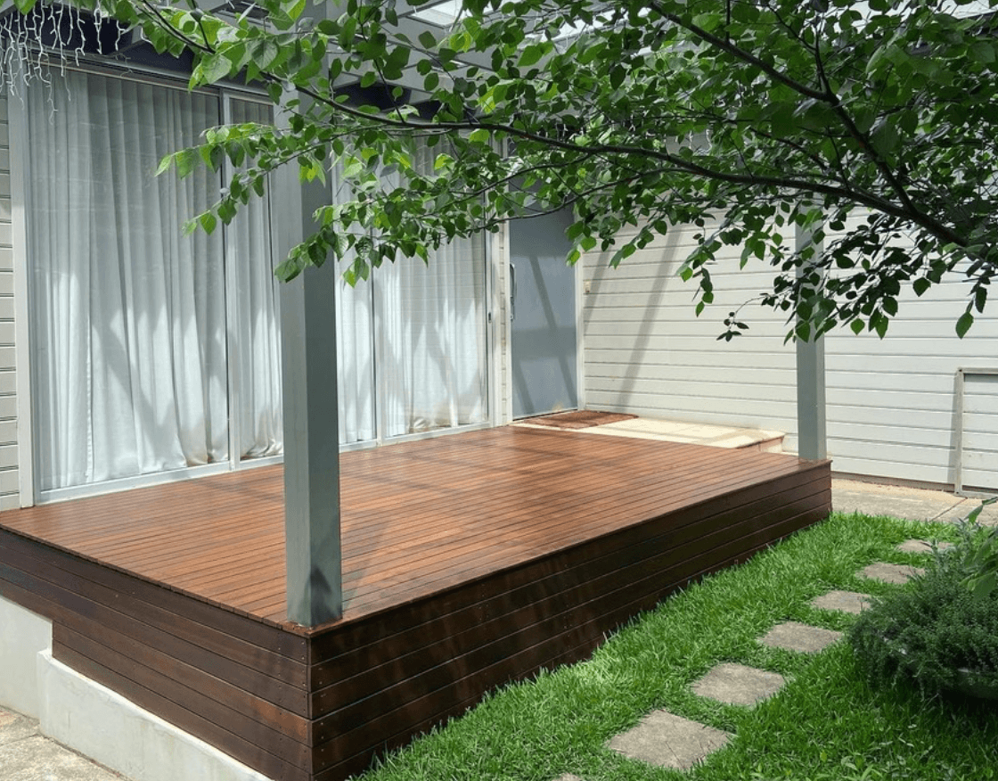 Raised timber deck with dark-stained skirting under a leafy tree in Endeavour Hills, by Northern Star Painting