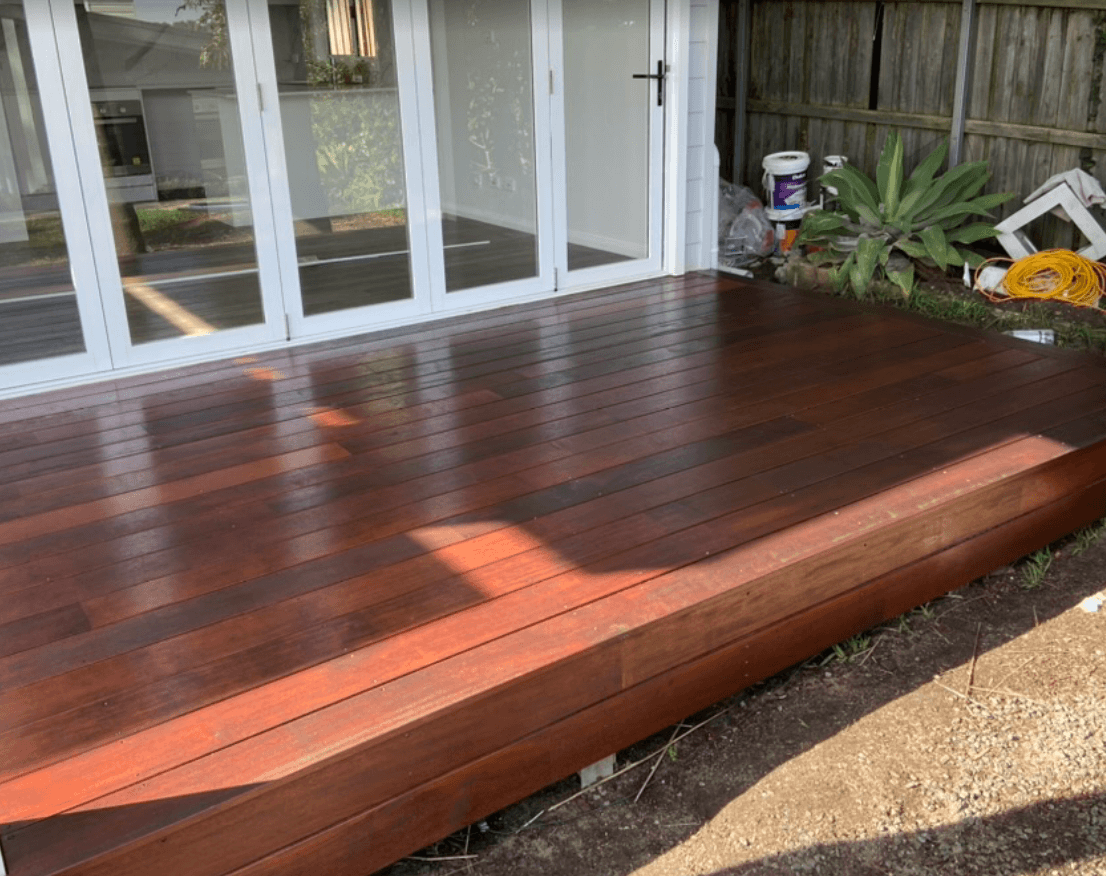 Reddish-brown timber deck outside white bi-fold doors in Harkaway, finished by Northern Star Painting