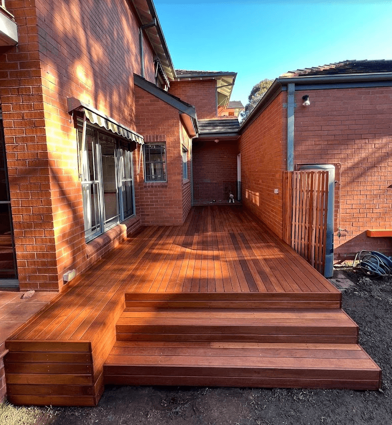 Hardwood deck with wide timber steps beside a red-brick home in Endeavour Hills, by Northern Star Painting
