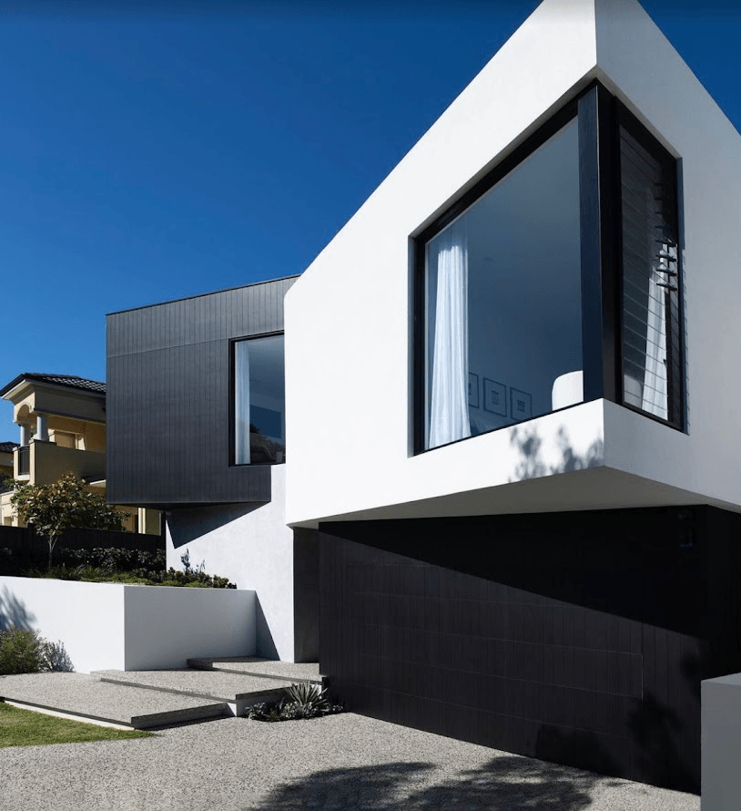 Freshly painted modern two-storey home exterior in Brighton with crisp white render and charcoal cladding by Northern Star Painting